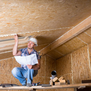 Home inspector looking at new construction of attic